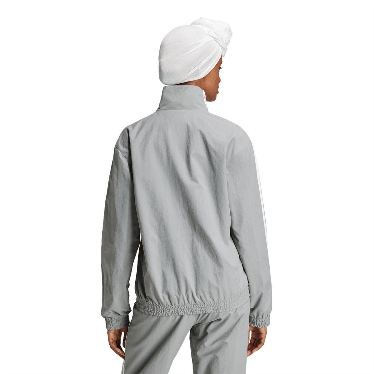 Grey adidas Originals track jacket, back view with white side stripes and ribbed hem