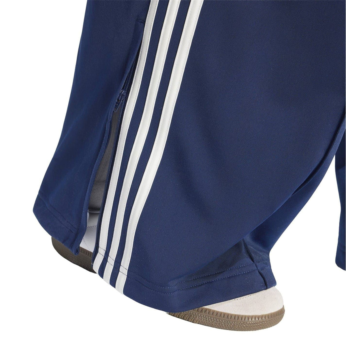 Loose dark navy track pants with wide cuffs and vertical white side stripe detailing