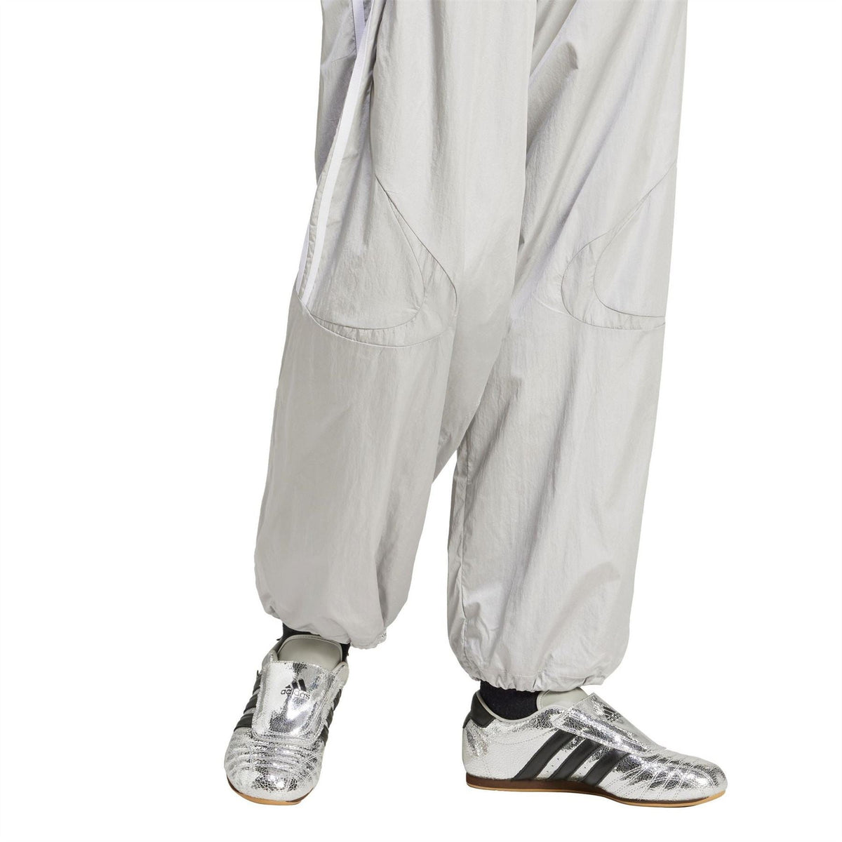 Light grey track pants with side pockets and elastic cuffs, tapered relaxed fit