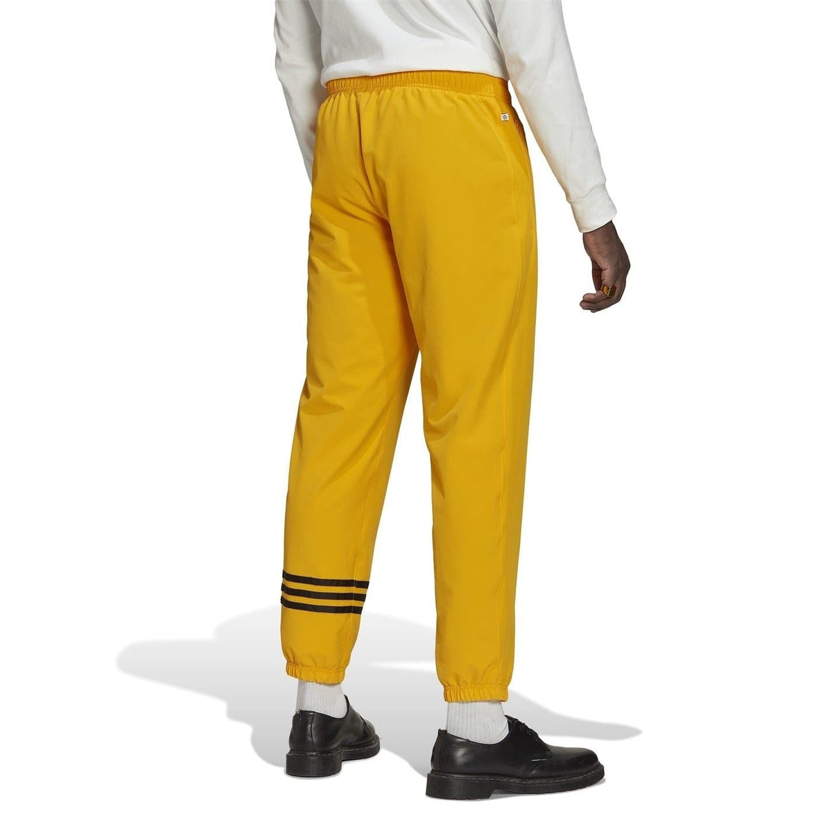 Gold tapered joggers with ribbed ankle cuffs and black triple stripe band