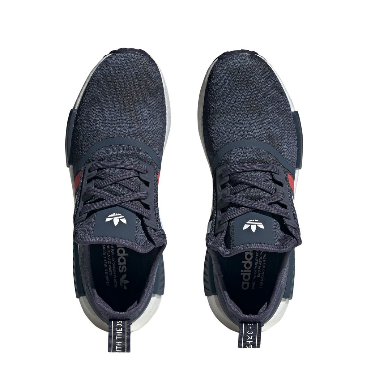Pair of navy adidas NMD R1 sneakers shown from toe and lace side
