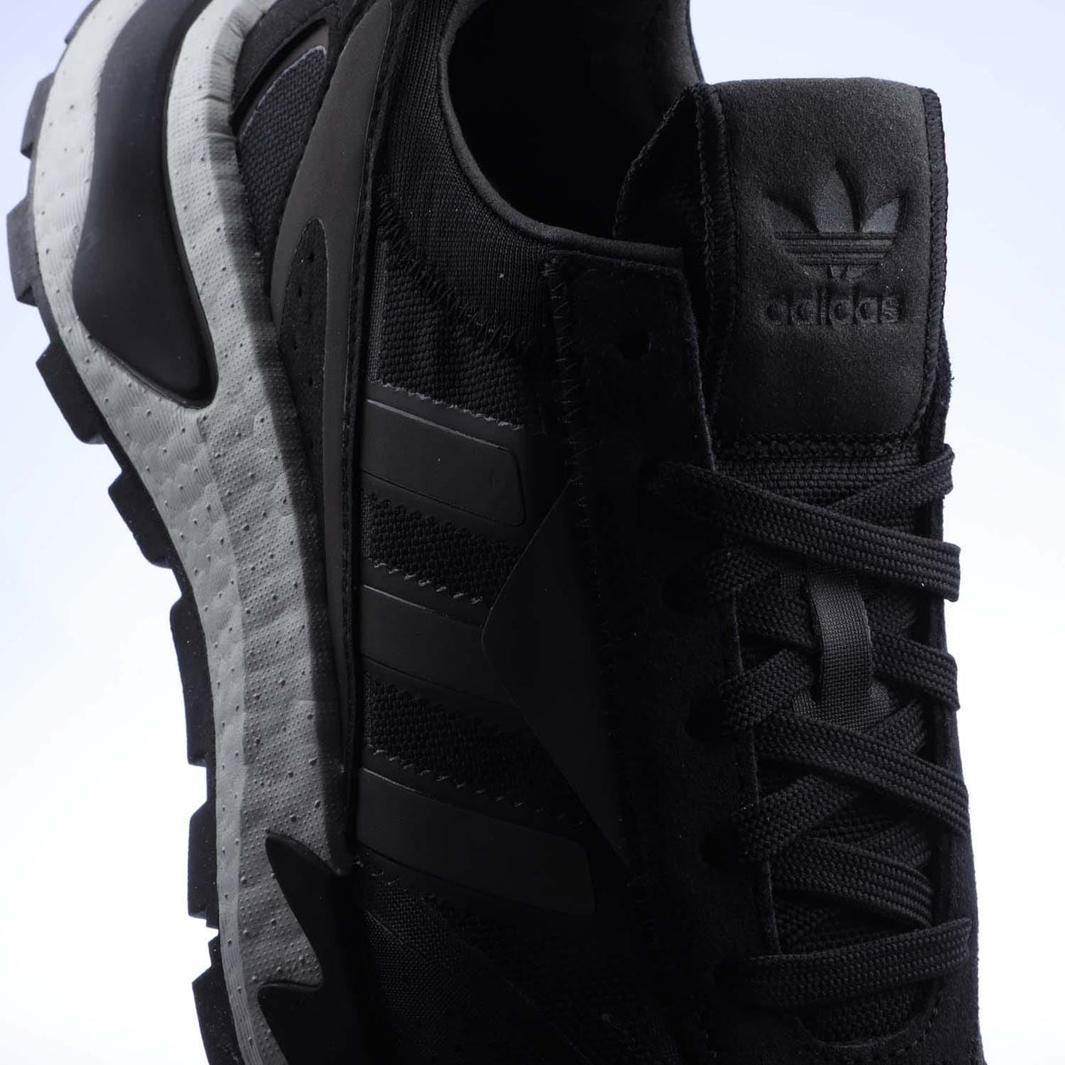 Black trainers close-up of heel and laces, showing adidas logo on the back.