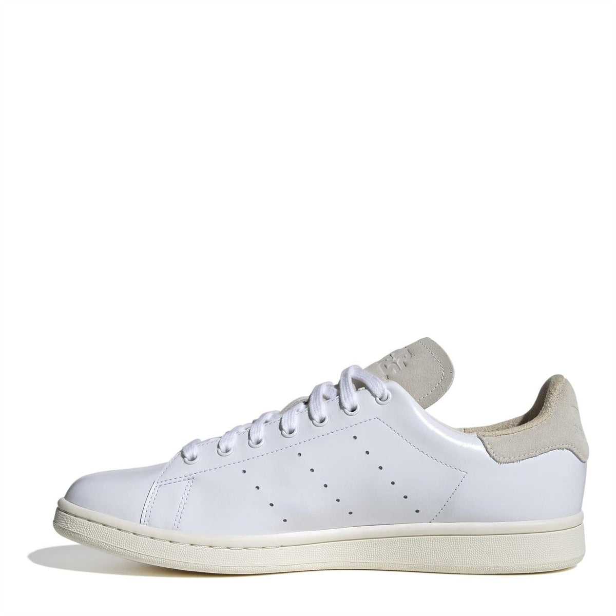White low-top sneakers with lace-up front, perforated toe cap, and beige outsole