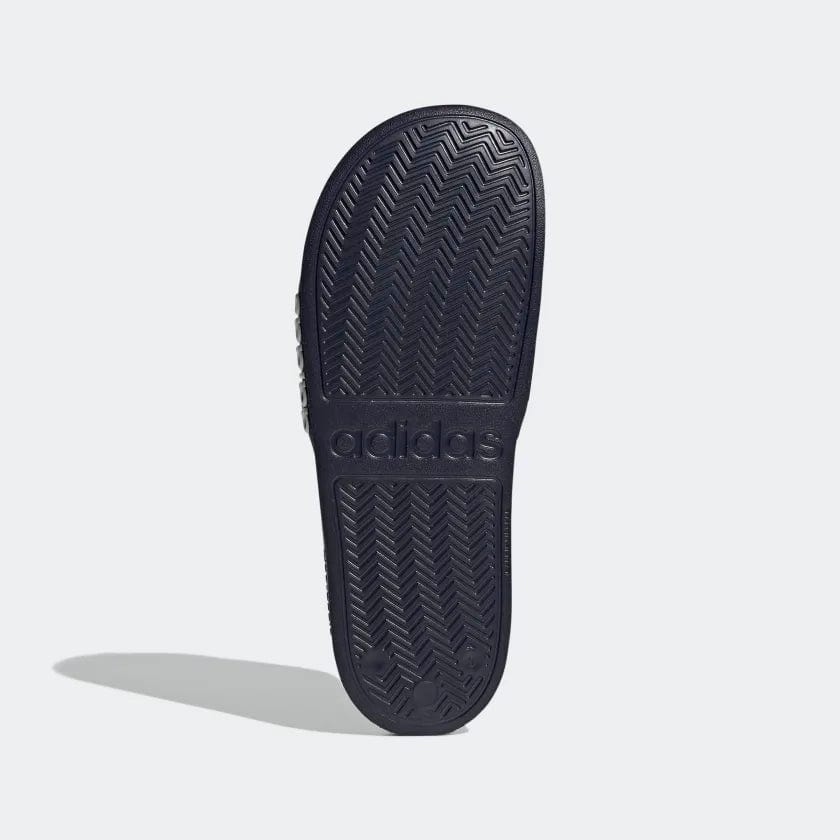 Navy shower slide sandals outsole with textured herringbone tread and adidas logo