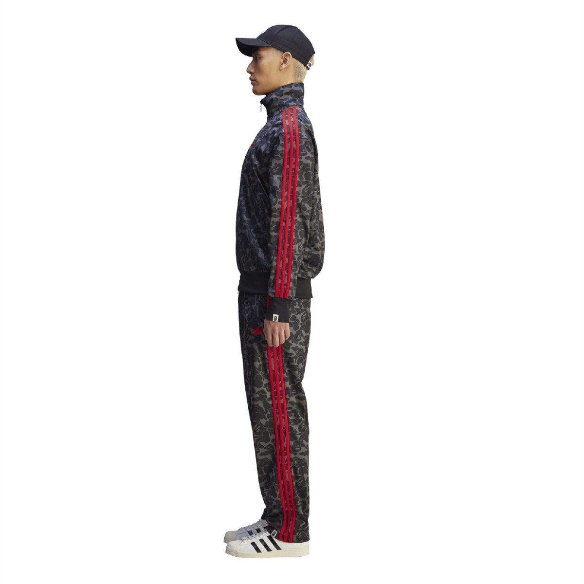 Camo trackpants with red vertical side stripes and tapered leg opening.