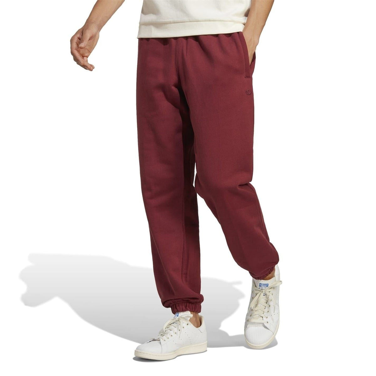 Burgundy track pants with tapered legs, elastic cuffs, and drawstring waist