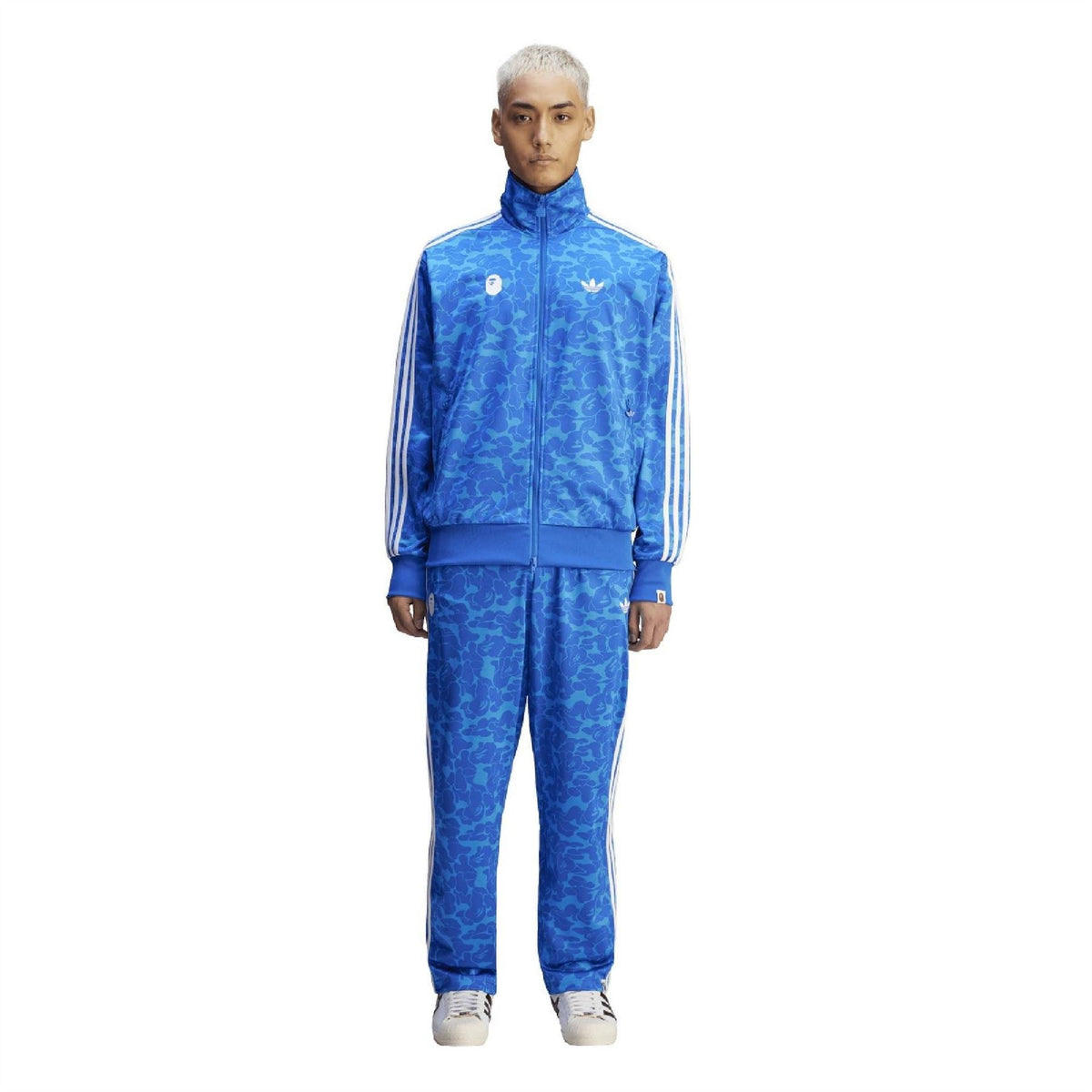 Blue camo track pants with elastic waist, white side stripes, and tapered ankle cuffs