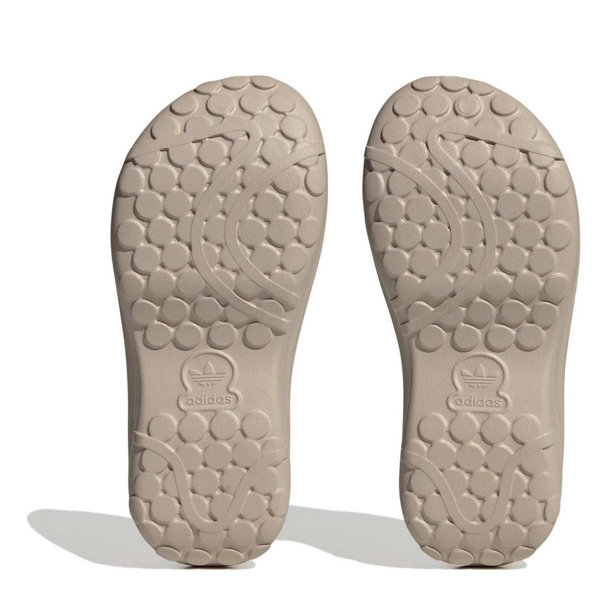Light tan low top trainer outsoles with Adidas logo and textured tread