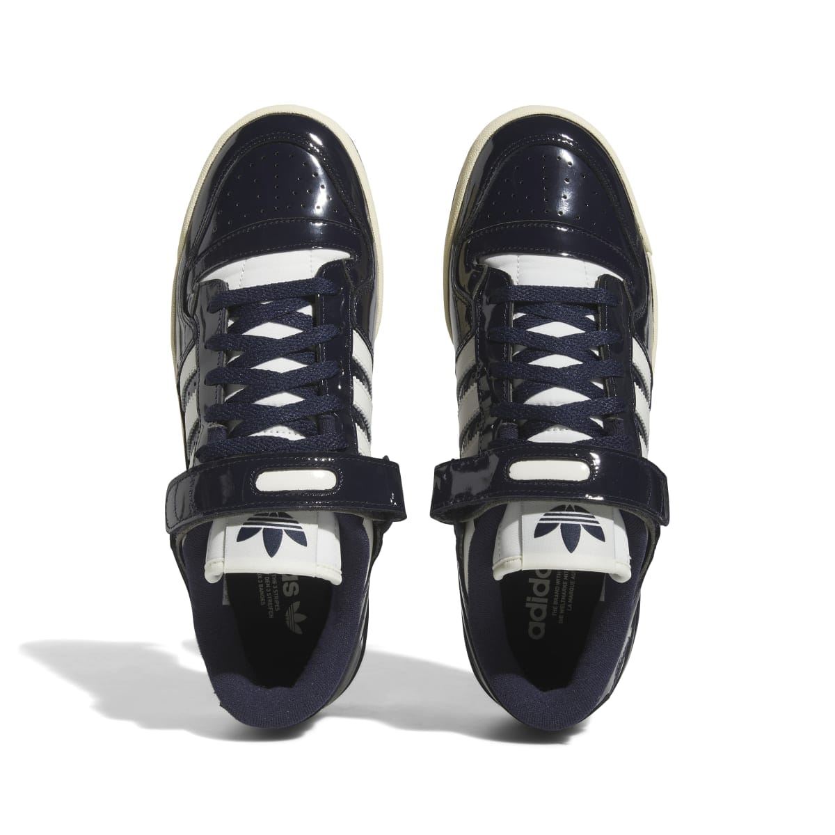 Pair of dark navy adidas low-top trainers with lace-up front and off-white heel lining