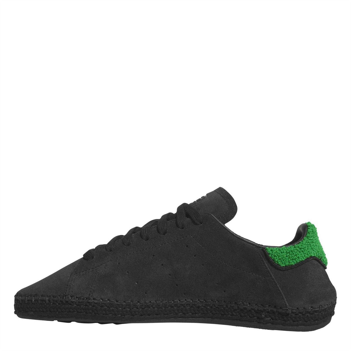 Black low-top trainers with green collar accent, lace-up and textured sidewall