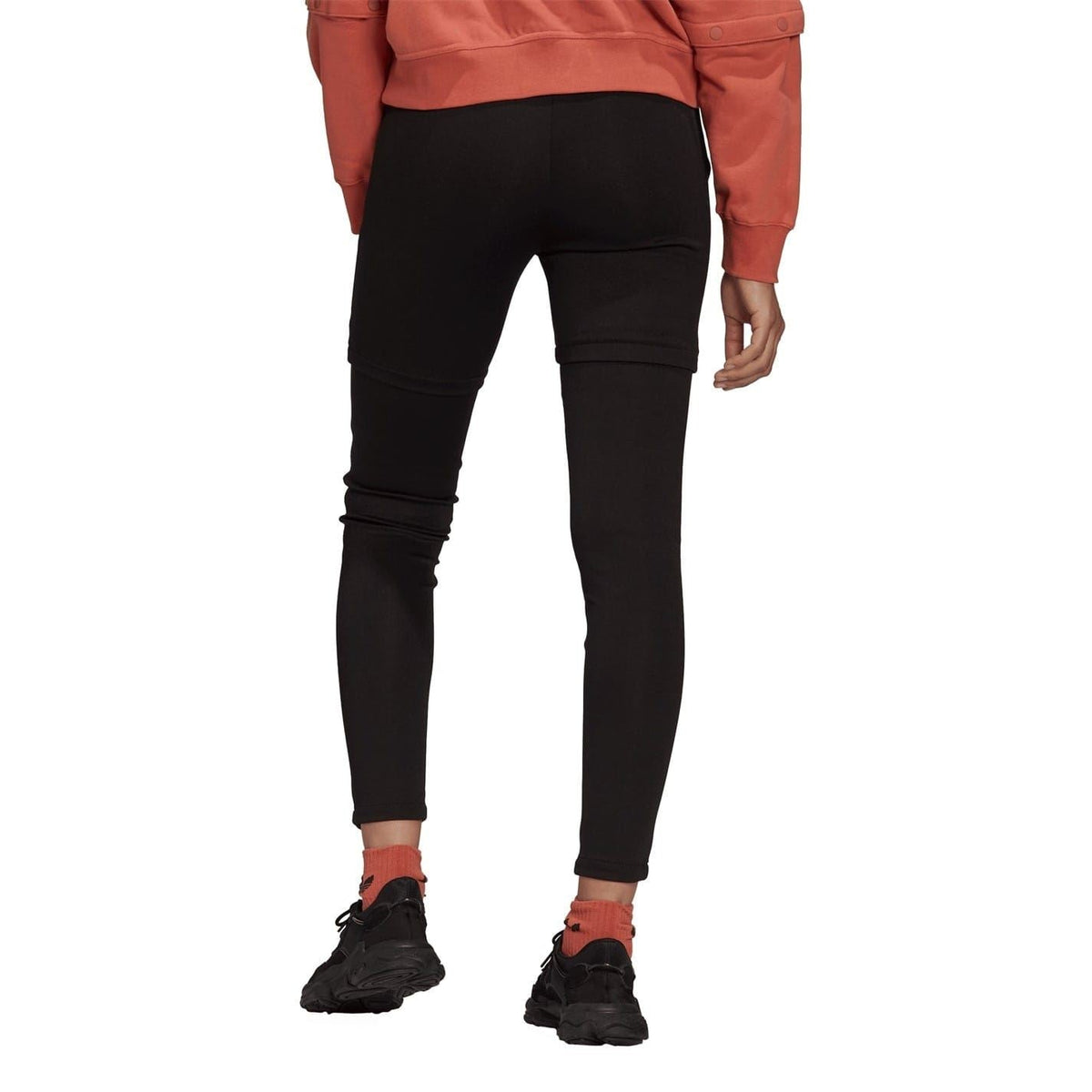 Black faux leather skinny trousers on model, back view with buttoned side panels