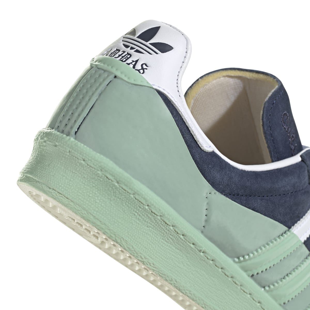 Heel and collar of trainers with navy suede, mint leather, and off-white pull tab