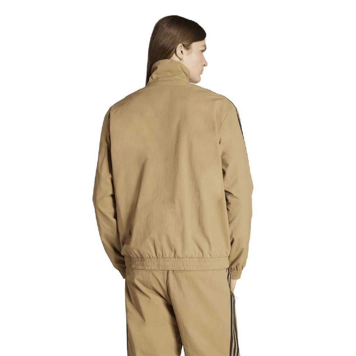 Back view of tan track jacket top with full-zip high neck and navy side stripes.