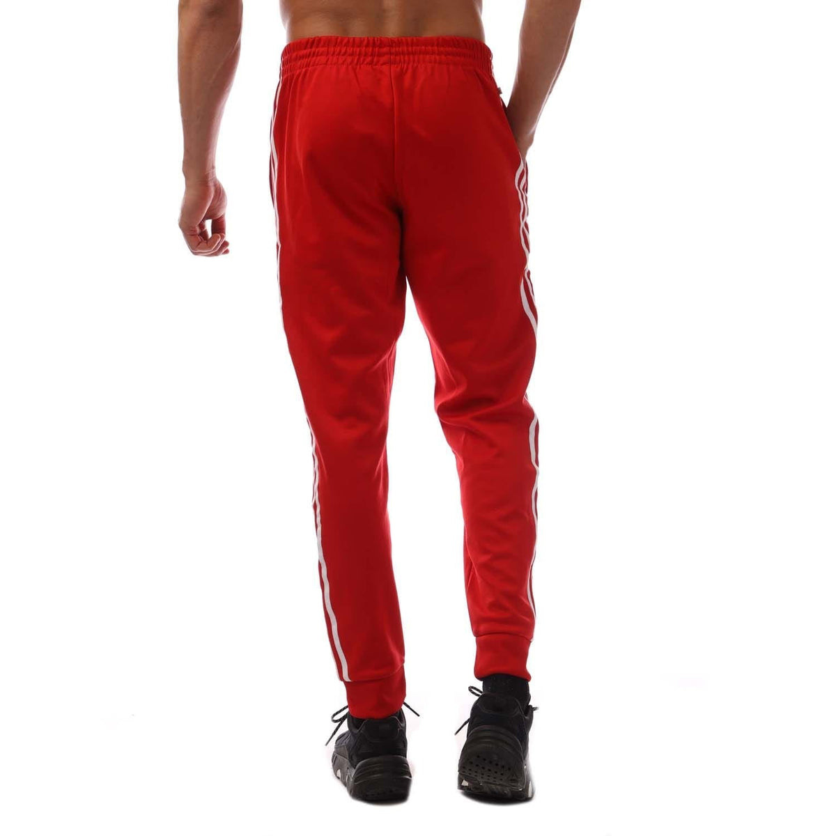 Red adidas track pants with white side stripes and ribbed elastic waistband