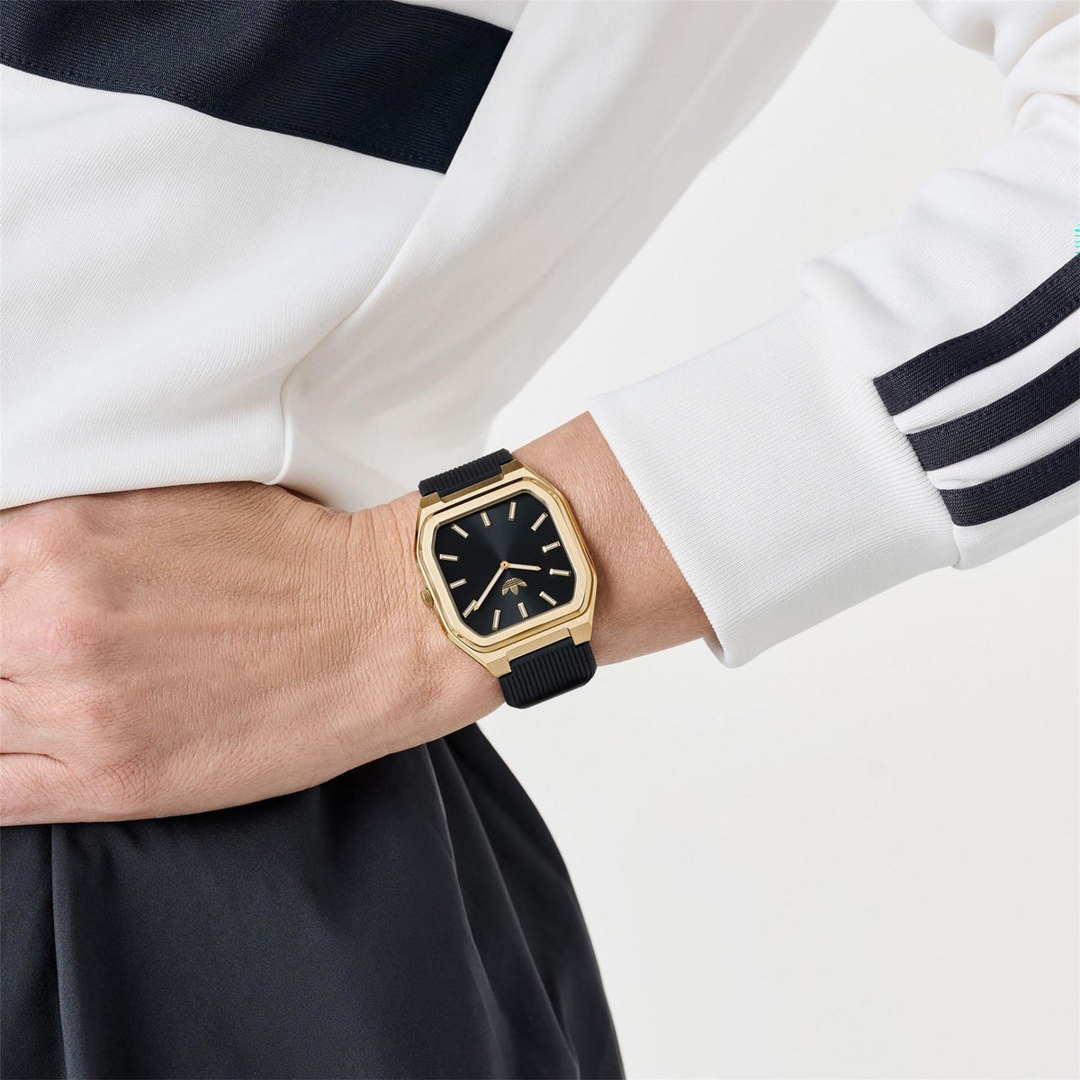 adidas Originals watch on wrist, black dial with gold-tone case and black ribbed strap