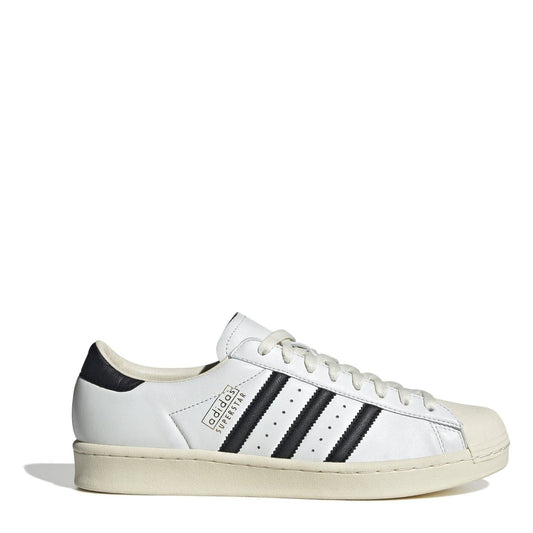 Cream leather-look sneakers with black adidas stripes and white lace-up