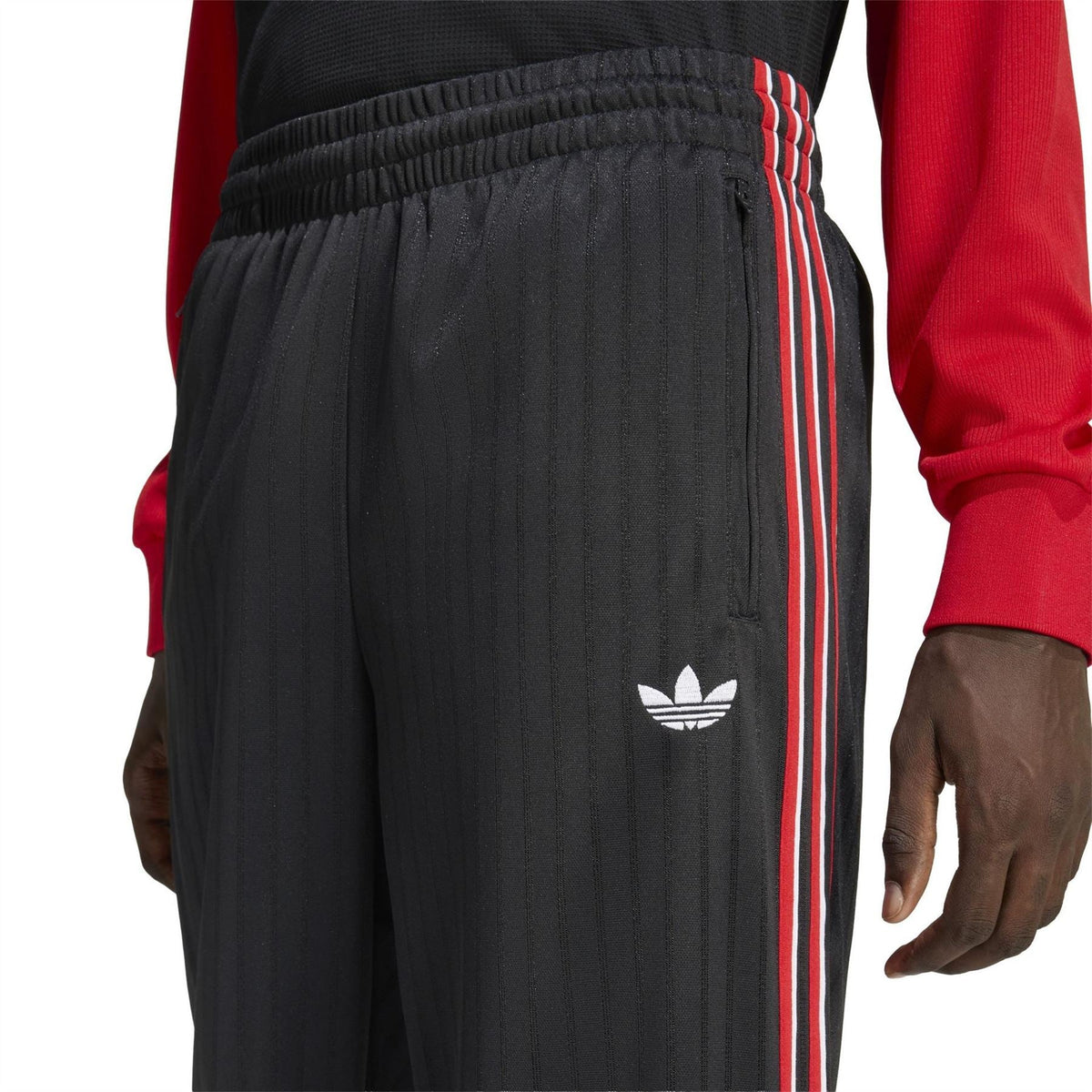 Black woven joggers with elastic waistband and small adidas trefoil on thigh
