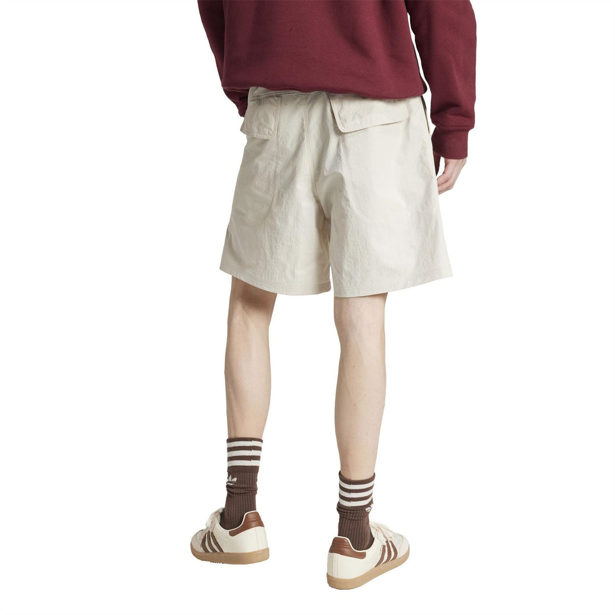 Light off-white shorts with back yoke seam and cargo pocket detail; knee-length