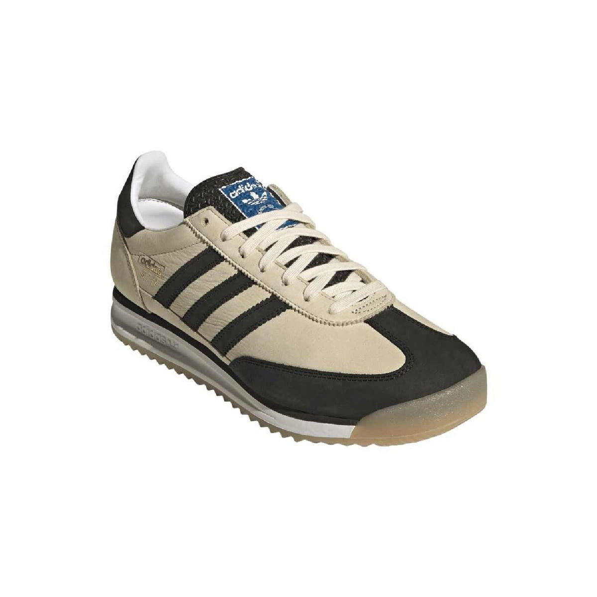 Beige and black adidas sneaker with speckled blue logo patch on the tongue