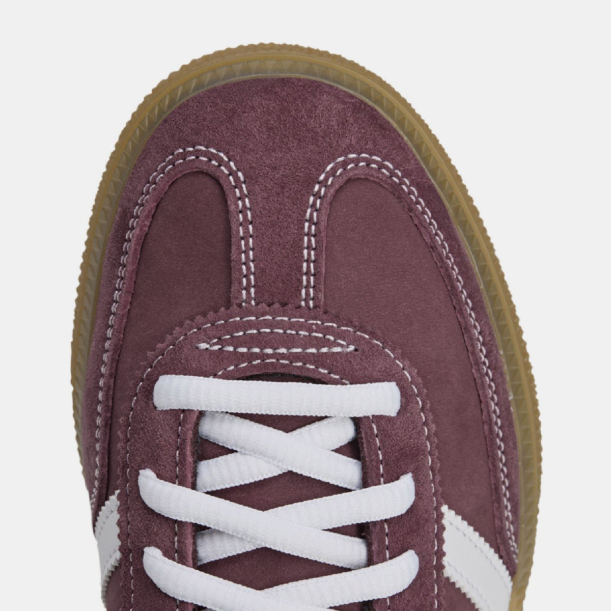 Burgundy suede adidas Spezial trainer close-up, white laces and stitched eyelets