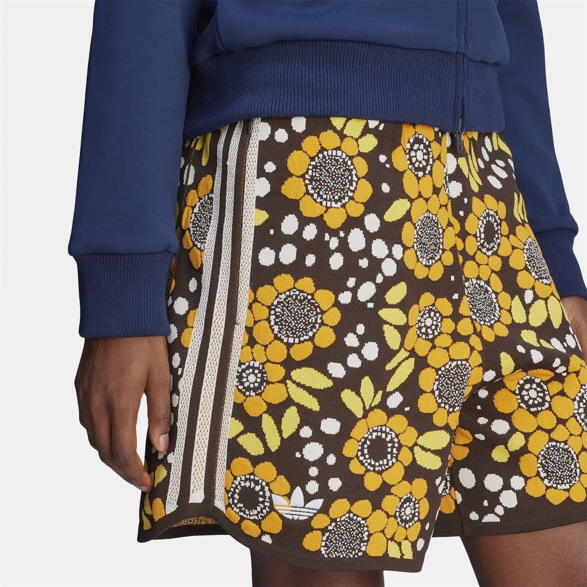 Close-up of floral knit shorts waistband and vertical side stripe on multicolour print