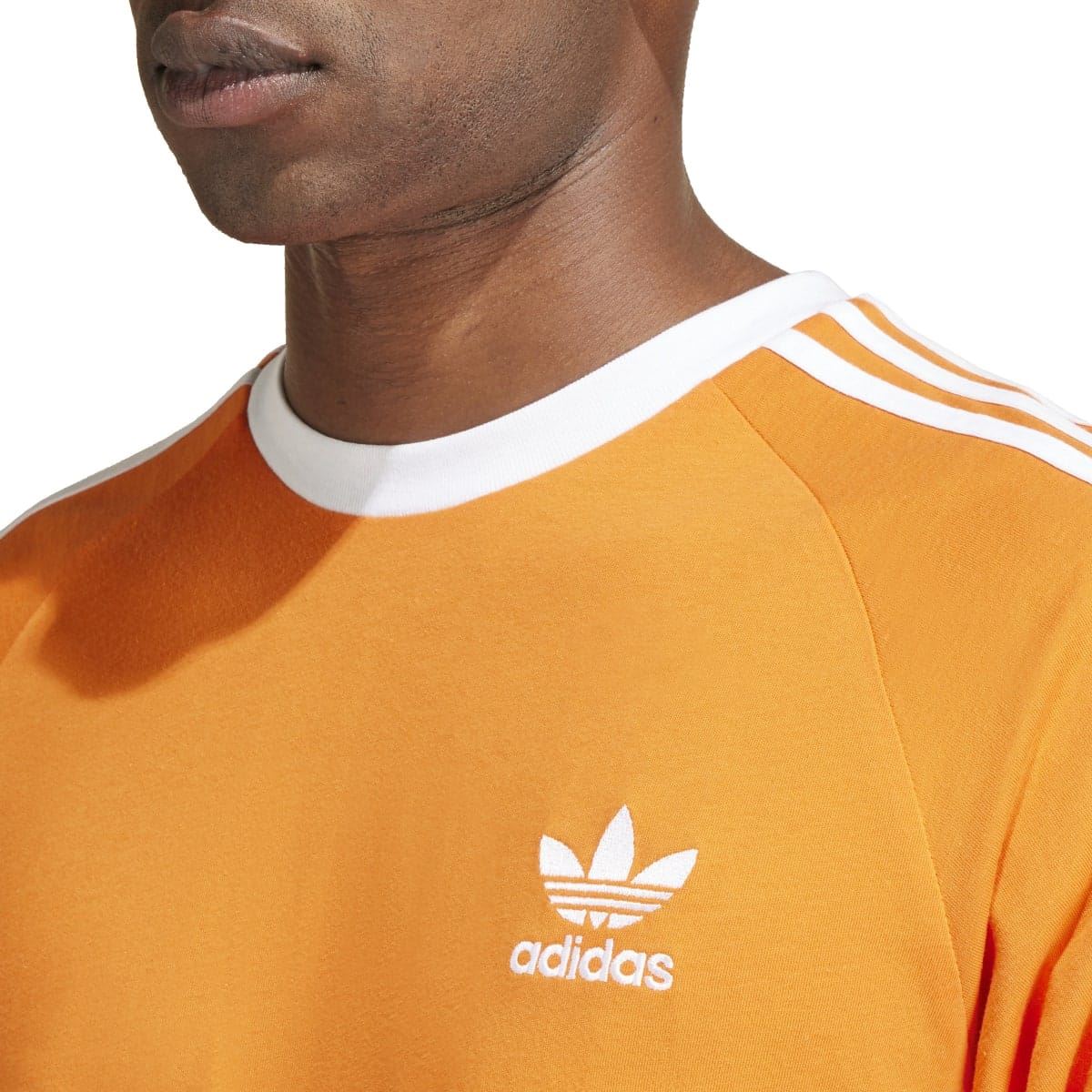Orange adidas Originals Adicolor T-shirt close-up of adidas trefoil chest logo