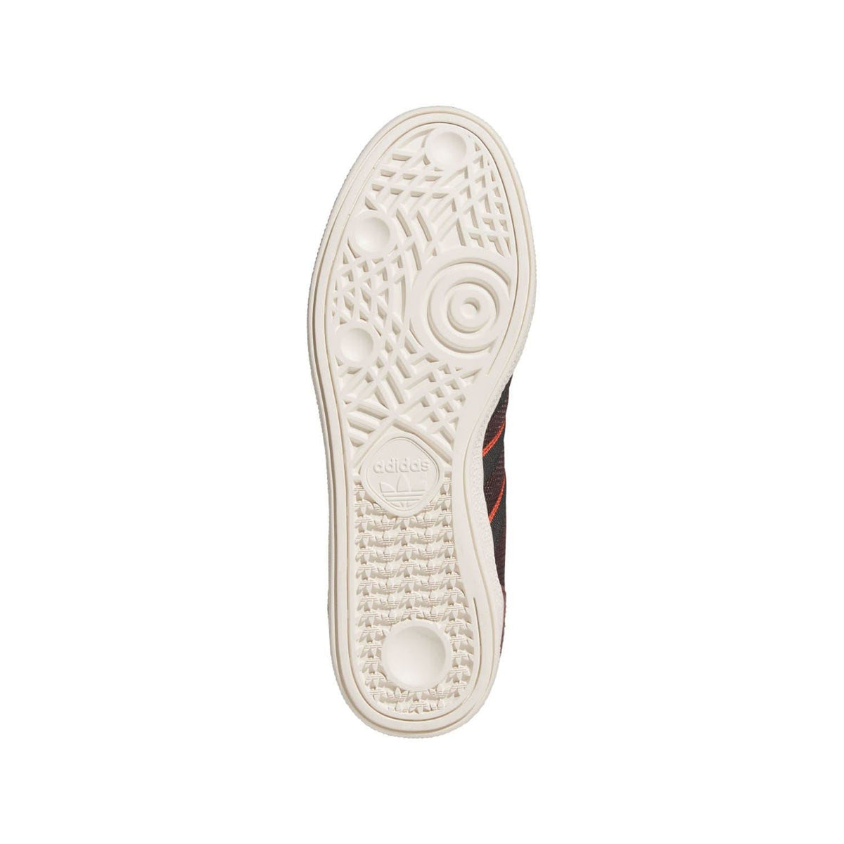 White rubber outsole of brown and black low-top trainers with adidas logo and tread pattern