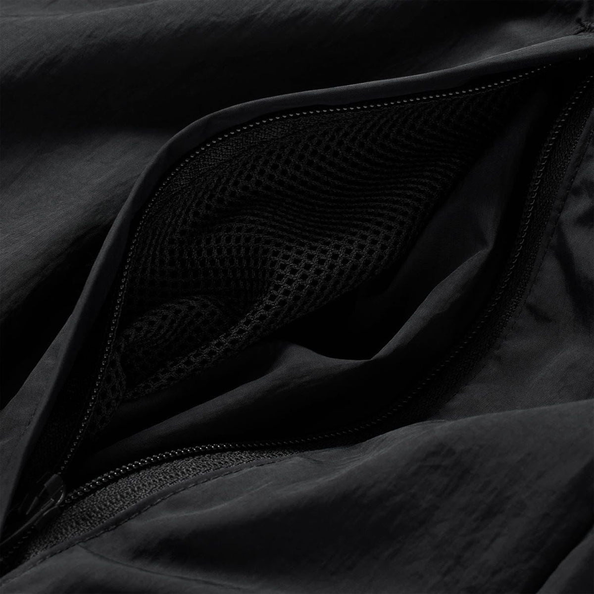 Black mesh-lined track jacket pocket with zipper detail