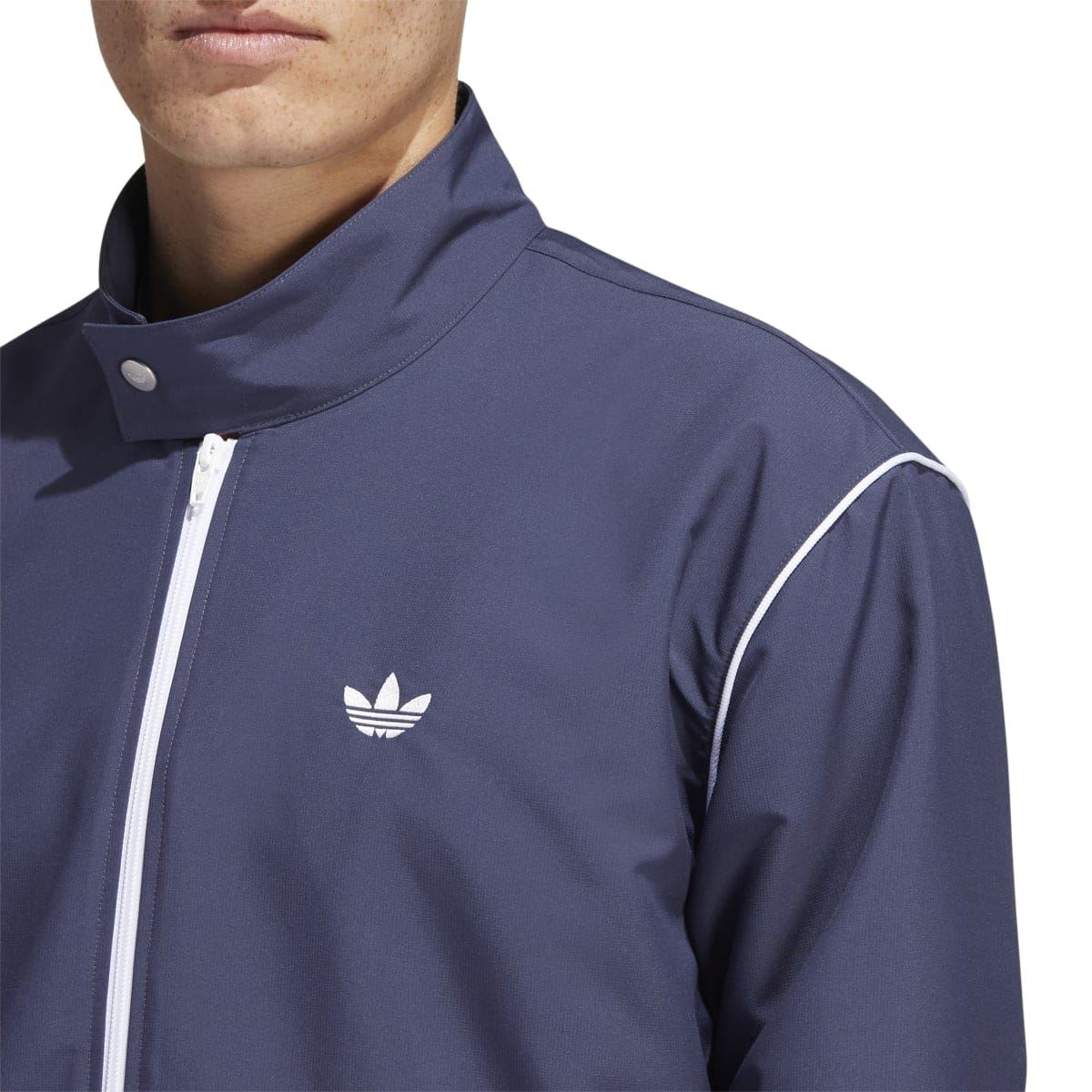adidas navy track jacket side close-up with chest trefoil logo and white zipper trim