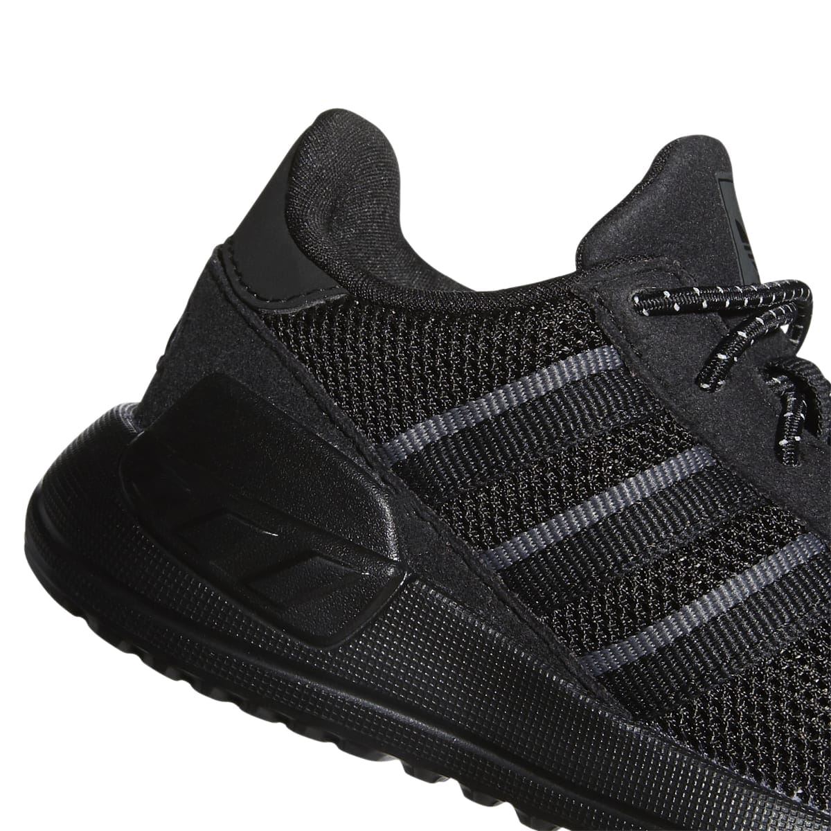 Infant trainer upper close-up: black knit, gray stripes, padded heel cage.