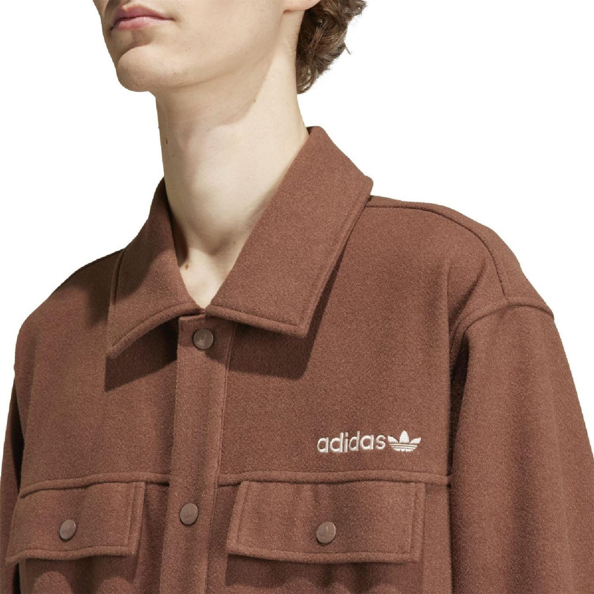 Brown adidas logo overshirt close-up with collared neckline and button details