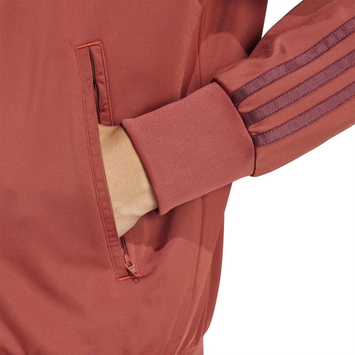 adidas Originals Firebird TT rust red track jacket close-up, side zip pocket and rib cuff