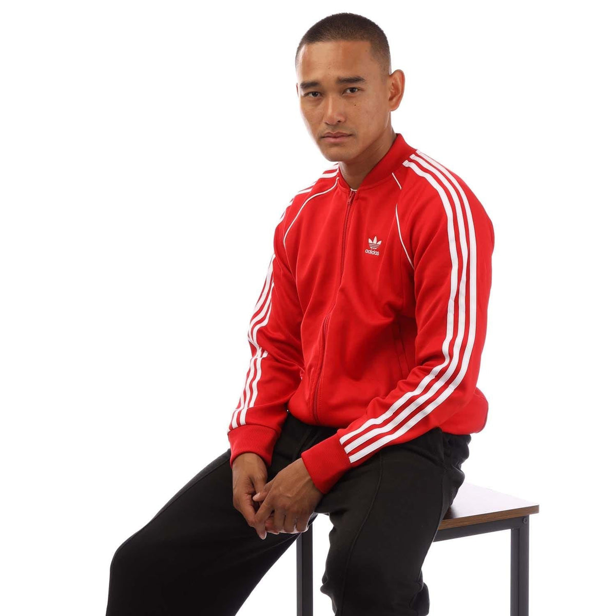 Red Adidas Originals track jacket with white sleeve stripes and ribbed cuffs