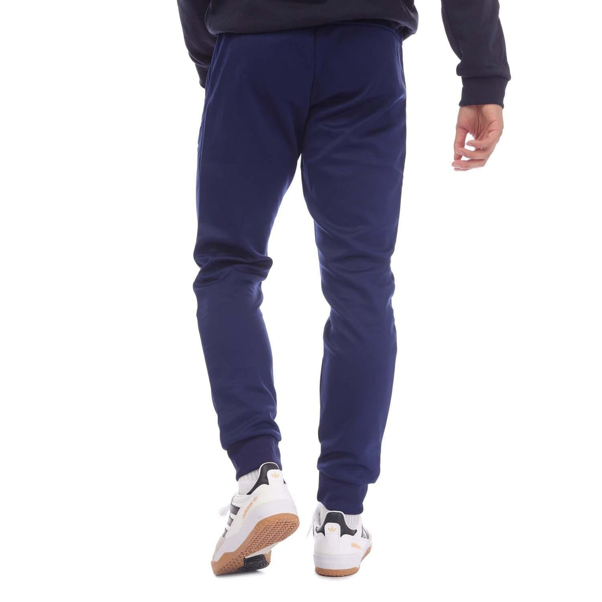 Navy track pants with tapered leg, ribbed cuffs, and adidas logo at ankle