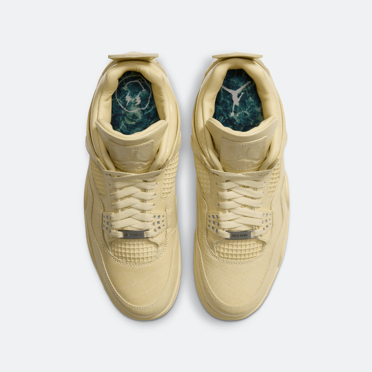 Pair of yellow sneakers showing teal patterned insides at the openings