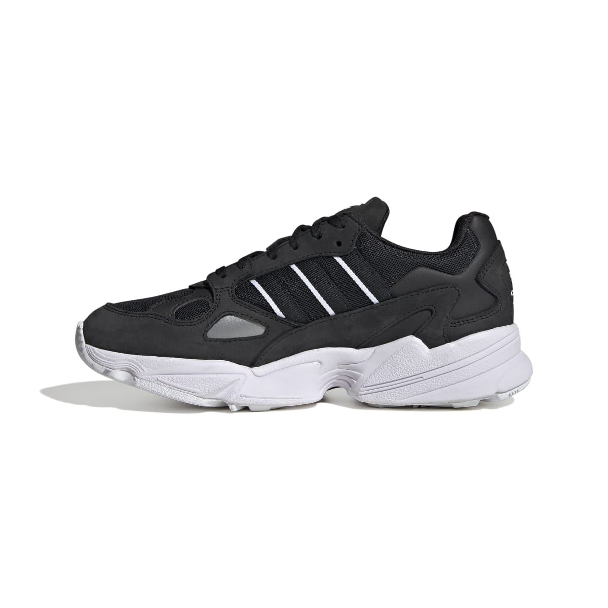 Black low-top sneakers with three stripes, perforated overlays, and white midsole