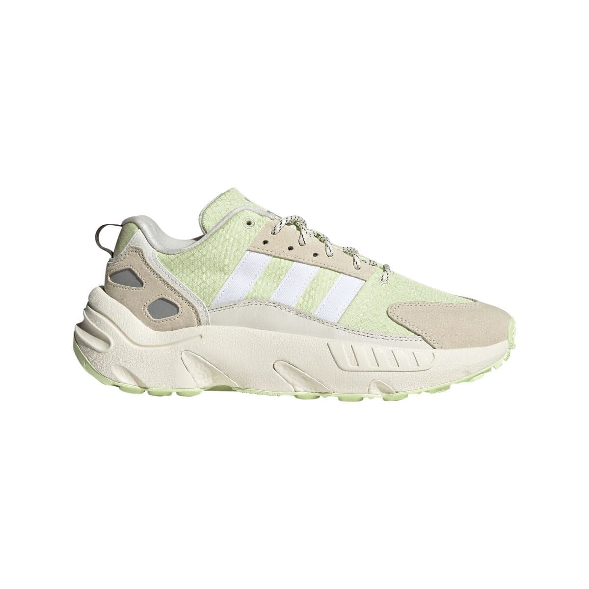 Off white low-top trainers with light green upper, suede overlays, and lace-up closure