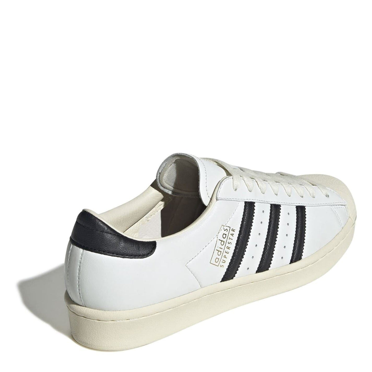 Back view of cream sneakers with black heel tab and three black side stripes