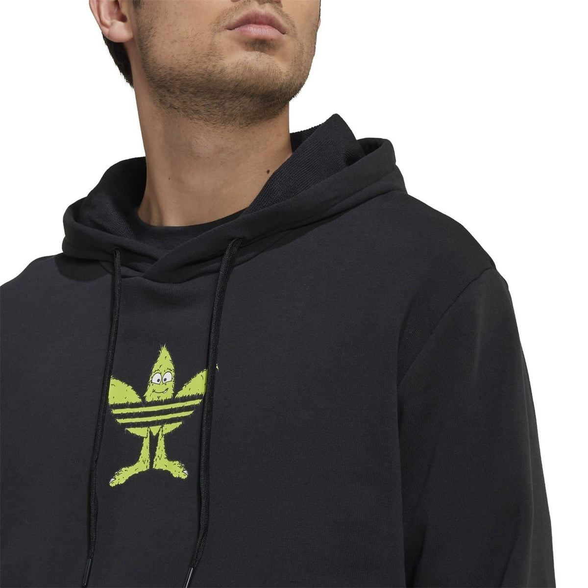 Black pullover hoodie close-up with green trefoil logo and drawstring hood.