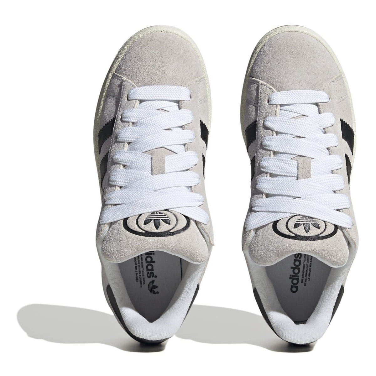 Light gray adidas low top sneakers with white laces and cushioned tongue detail