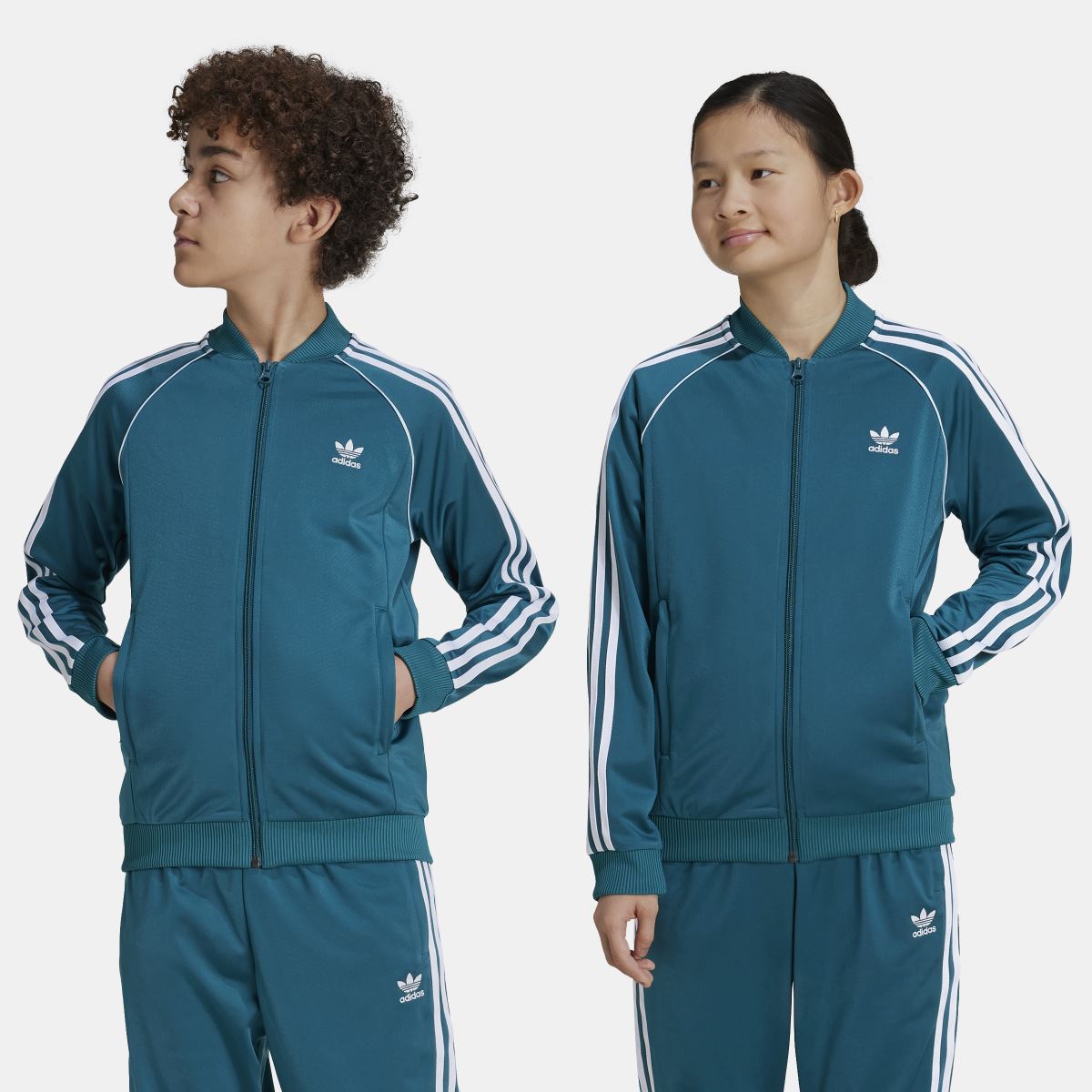 Teal kids track top with full zip, white stripes on sleeves, and adidas trefoil logo.