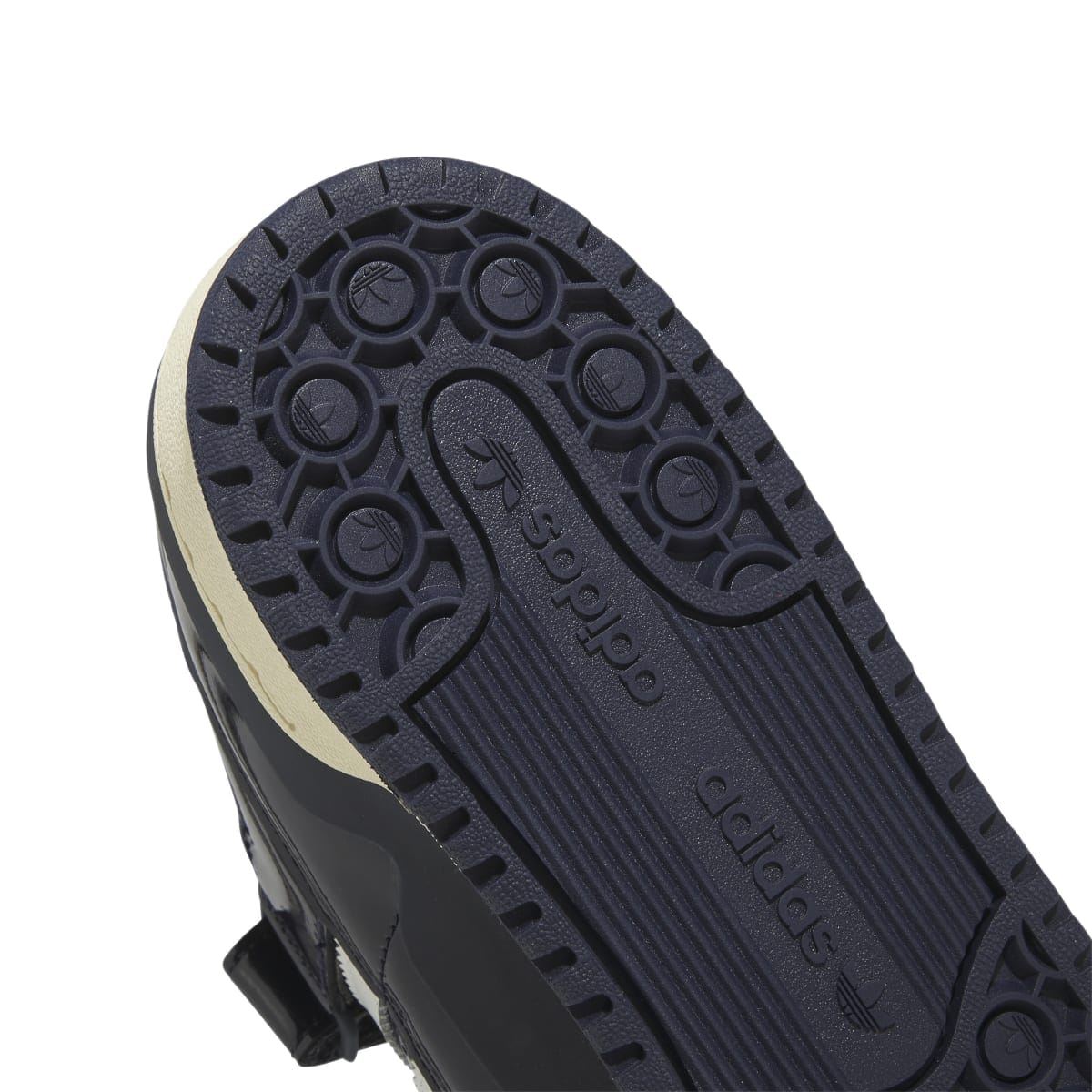 Close-up outsole of dark navy adidas low-top trainers with textured circular tread
