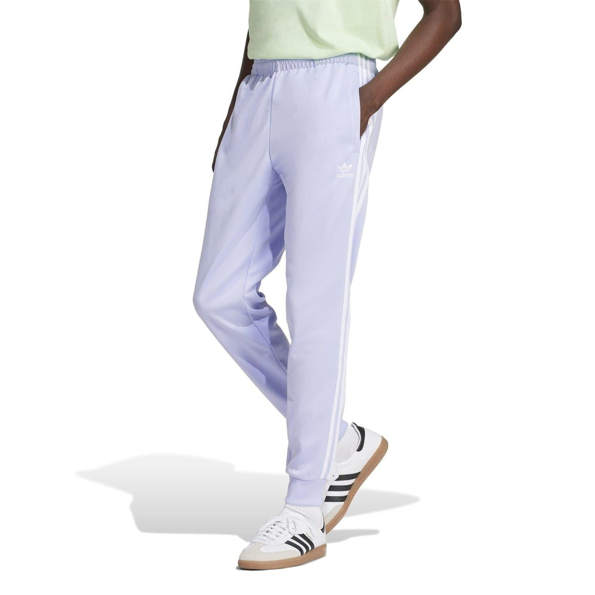 Light purple adidas track pants with side stripe detail and tapered jogger legs