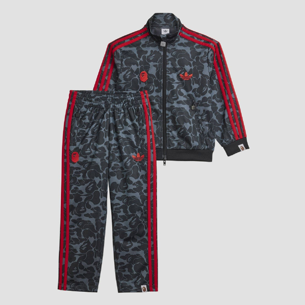 Kids camo tracksuit jacket with red zip, triple sleeve stripes, and ribbed cuffs