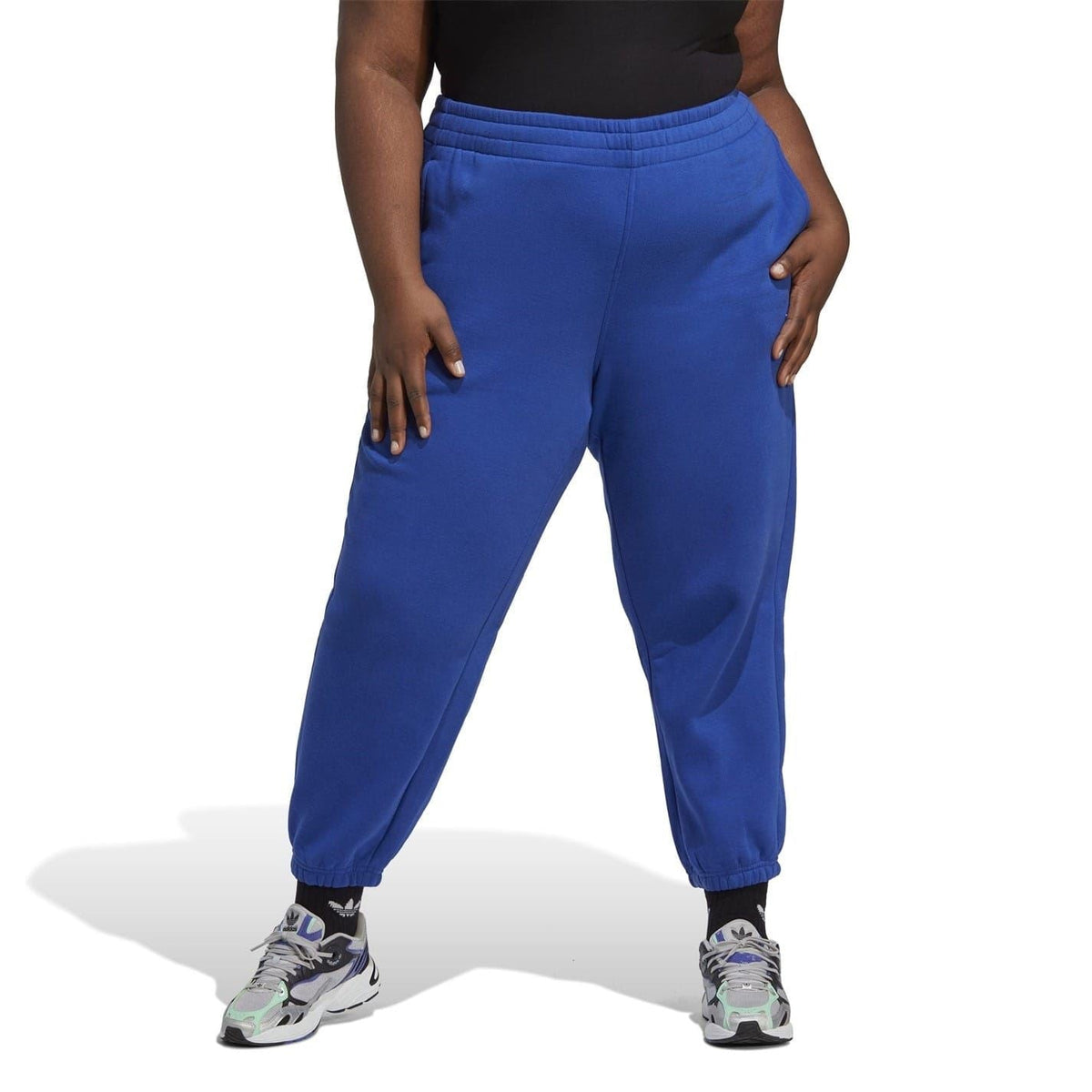 Blue tapered joggers on model with cuffed ankle and elastic waistband