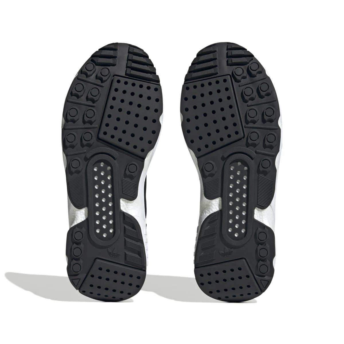 Outsoles of black ZX 22 Boost trainers with rubber tread and perforated traction pods