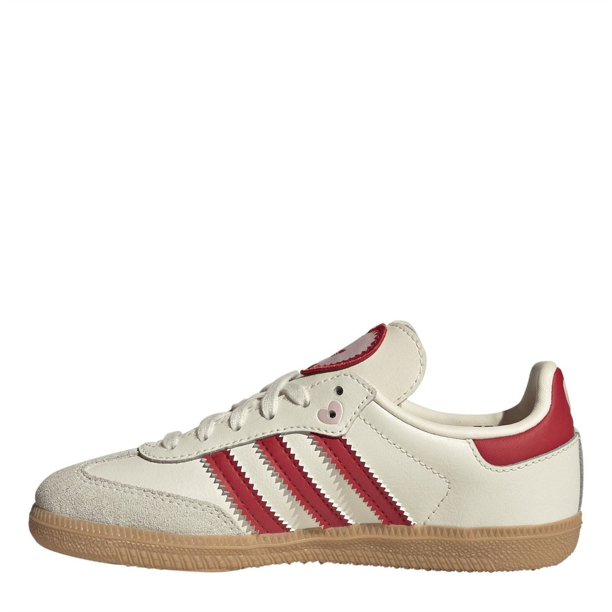 Low-top sneaker side view in cream with red adidas-style stripes and gum sole