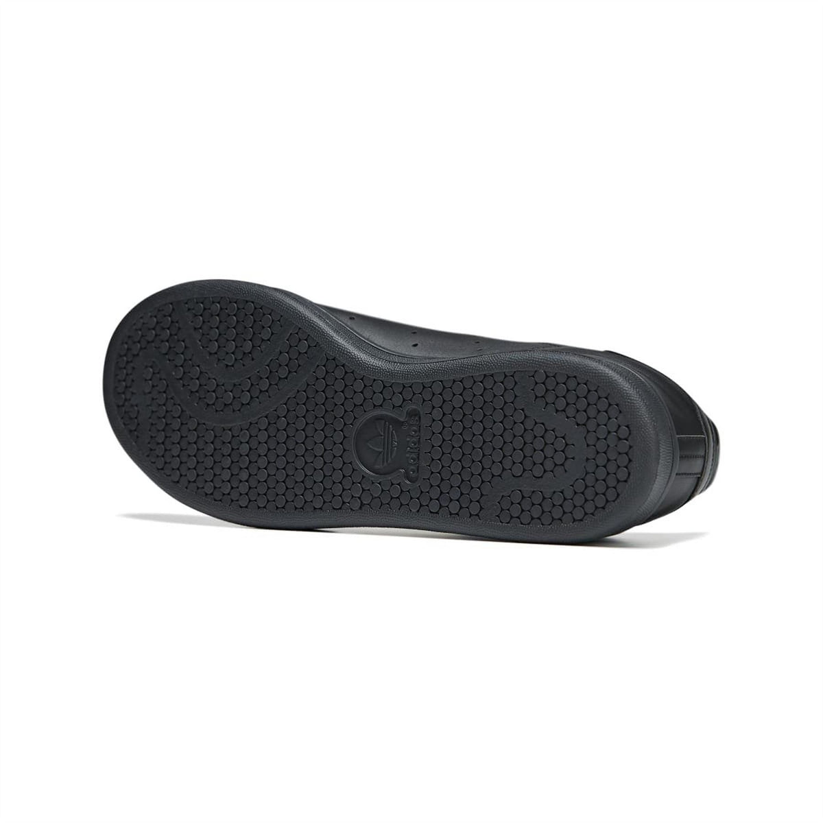 Black rubber outsole of a low-top lace-up sneaker with textured tread