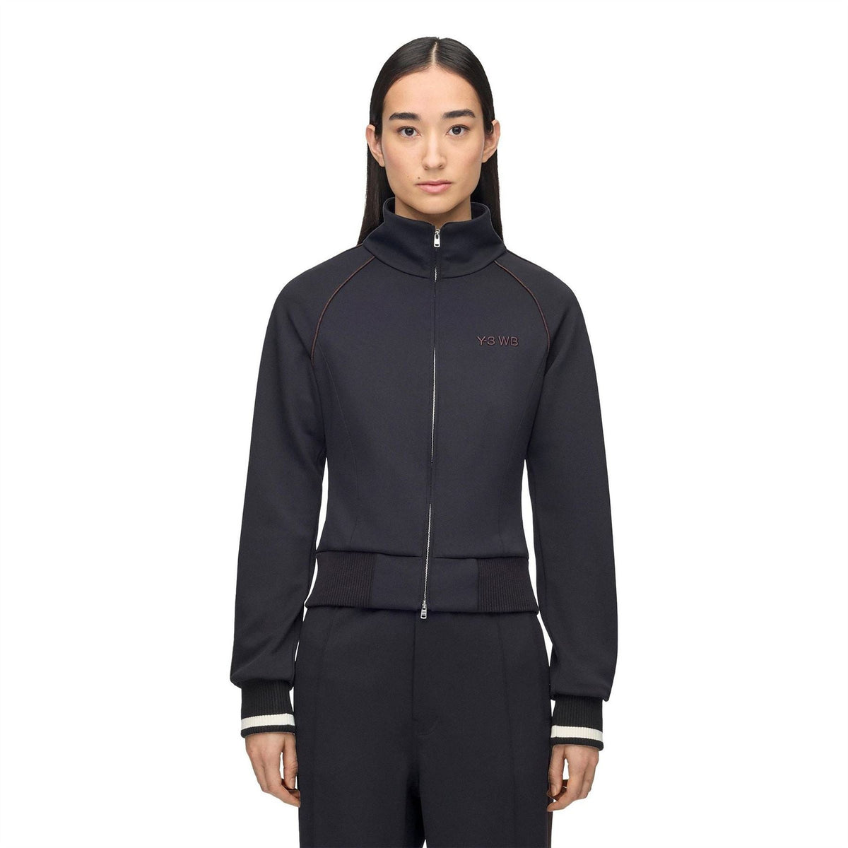 Black track jacket on model with full zip, stand collar, ribbed hem and cuffs