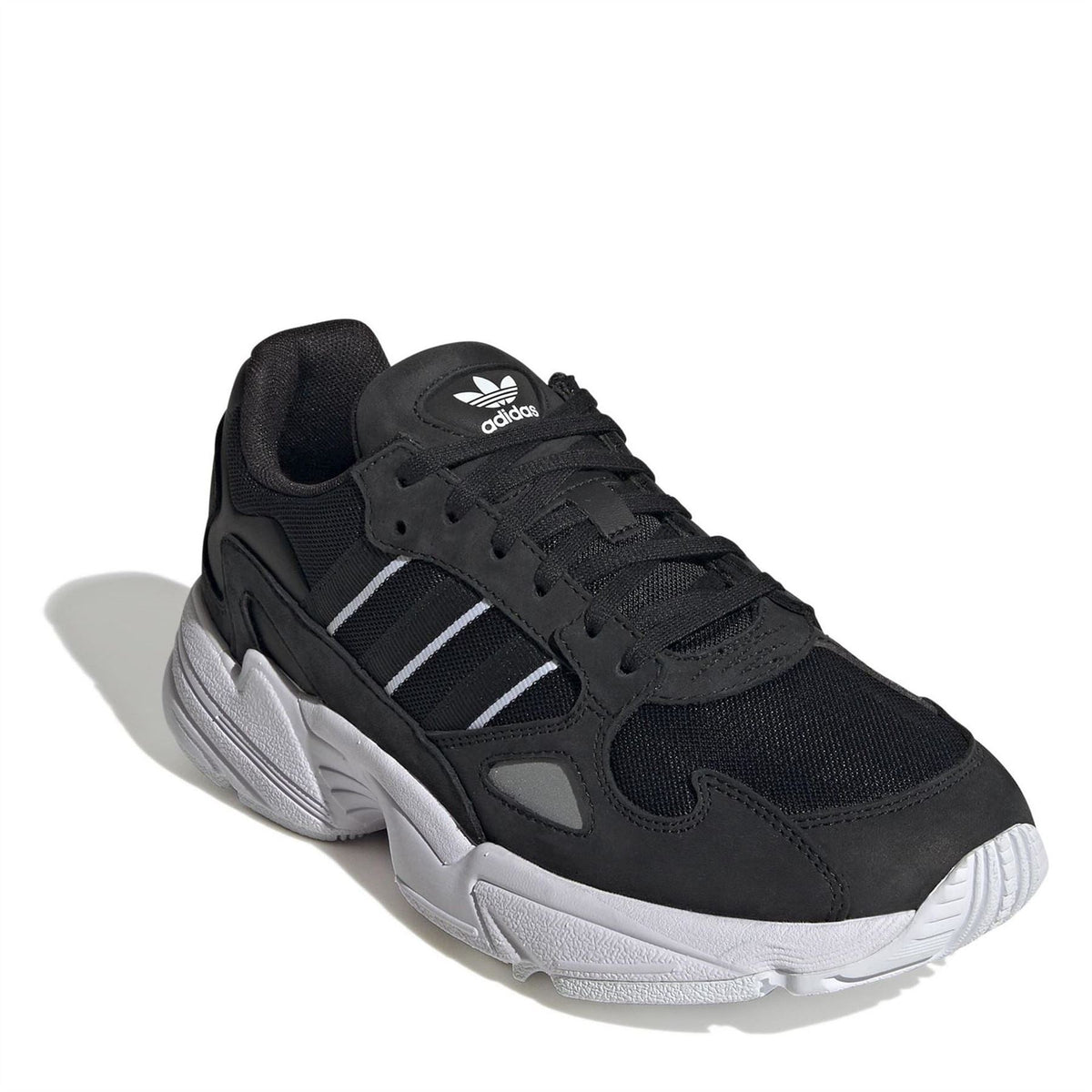 Black low-top lace-up sneakers with white stripe accents, adidas logo, and white sole